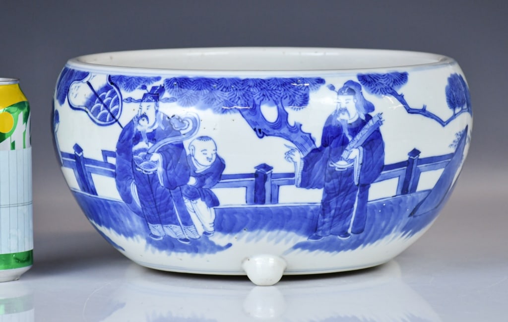 A Lrg Blue & White Figures Tripod Censer Qing: The deep rounded body is raised on three short feet, painted around the exterior with a narrative scene depicting figures conversing on a balustraded terrace beneath an overhanging pine tree, all