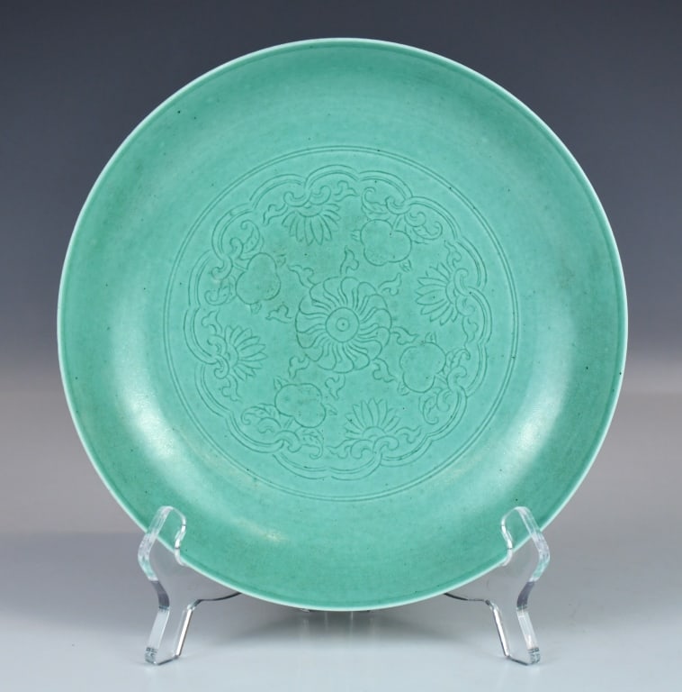 Green Glazed Eight-Treasure Plate Qianlong Mk Qing: Covered overall with green glaze and incised to the interior with floral and fruit motifs centred by a floral medallion; the exterior is decorated with a continuous band of auspicious emblems; six cha