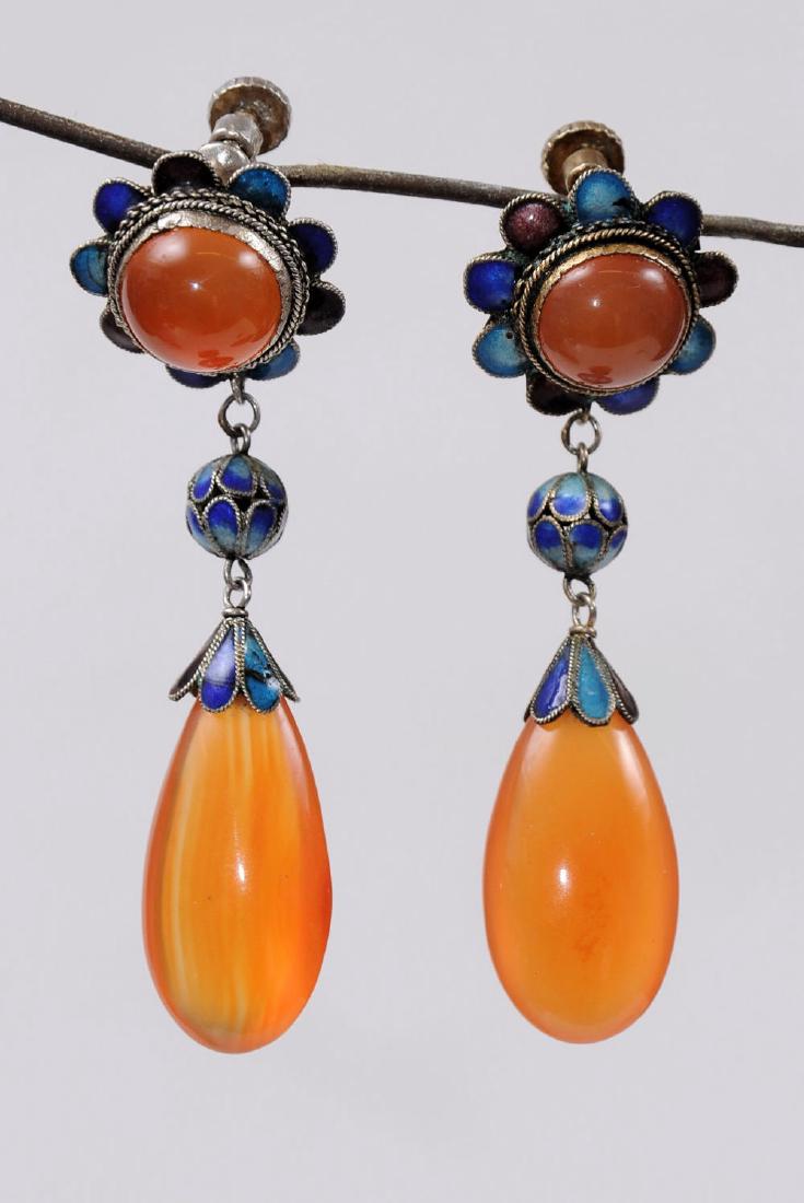 A pair of special earrings set with Carnelian cabochon: A pair of special earrings set with Carnelian cabochon and a dropshaped Carnelian, featuring Russian style enamel work. Approx. length: 6 cm.