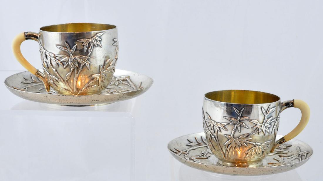 Pr. of Chinese Decorated Silver Cups & Saucers: Chinese silver demitasse size cups and saucers decorated with bamboo designs in high relief. Measures - saucers 4 1/8"W; cups 1 7/8"H X 2 1/8"W. 160 grams each set; total of 320 grams. Light surface s