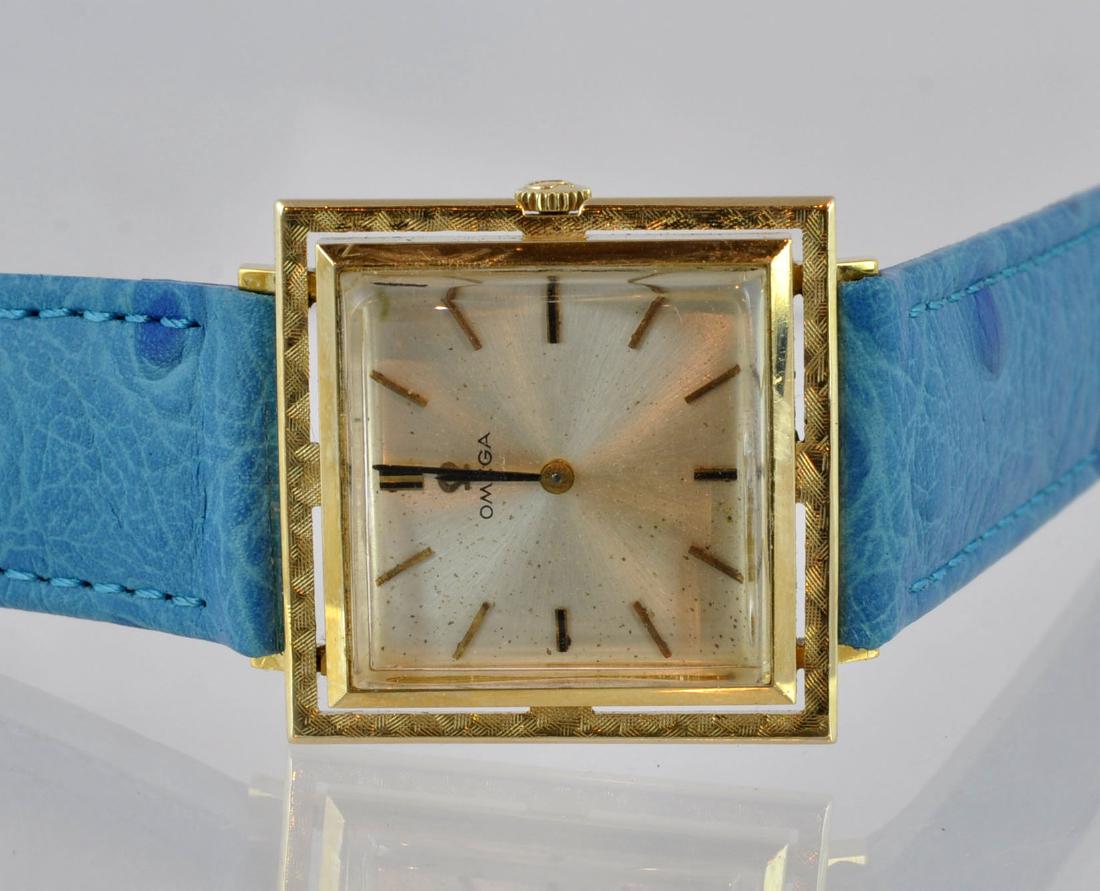 Omega Vintage 14kt Gold Capped Watch: Vintage square gold capped face with blue leather strap. Marked 14kt on back. Face measured from outside edge of crown 27.5mm; band 8.25". Working condition. See photos. In house shipping continental