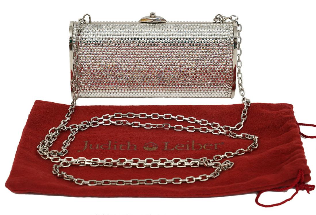 Judith Leiber Crystal Minaudiere Clutch Bag: Judith Leiber Minaudiere clutch encrusted with clear sparkling crystals. It boasts a long chain/shoulder strap that can be neatly tucked in to carry this bag as a clutch. Lined in silver leather. Incl