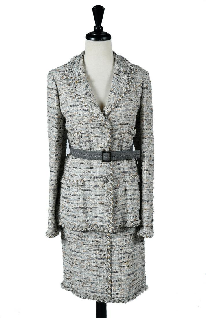 Chanel Grey & Gold Silk Boucle Skirt Suit Sz 40/42: Chanel grey boucle silk blend suit with shimmering gold and silver thread. Jacket is trimmed in matching braided boucle. Front and pockets boasts lion head ruthenium CC buttons. Straight skirt lined i