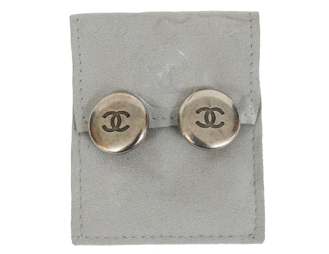 Chanel Silver Tone CC Button Clip On Earrings 1996: These Chanel silver tone round earrings are clip with a CC in the middle. Marked Chanel, Made in France, 96 P. Measures 3/4" and comes with grey Chanel pouch. Condition report: good condition, no issu
