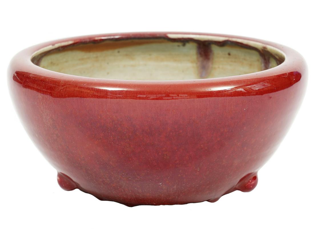 Sang de Boeuf Glazed Tripod Bowl: Sang de Boeuf glazed oxblood bowl, tapering ovoid form with inverted rim, 3 small lugs/feet near base. Measures 5"H x 10.75"W. Condition report: overall good condition, rough edges on bottom rim, see 