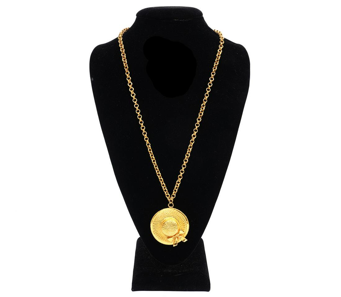 Chanel Vintage Hat Necklace 1970's: Vintage, 1970's, Chanel necklace featuring a gold tone hat adorned with a bow on a double link chain. Chain length 28", Pendant size 2" diameter. Made in France. Condition grade: 1. Examine all photos