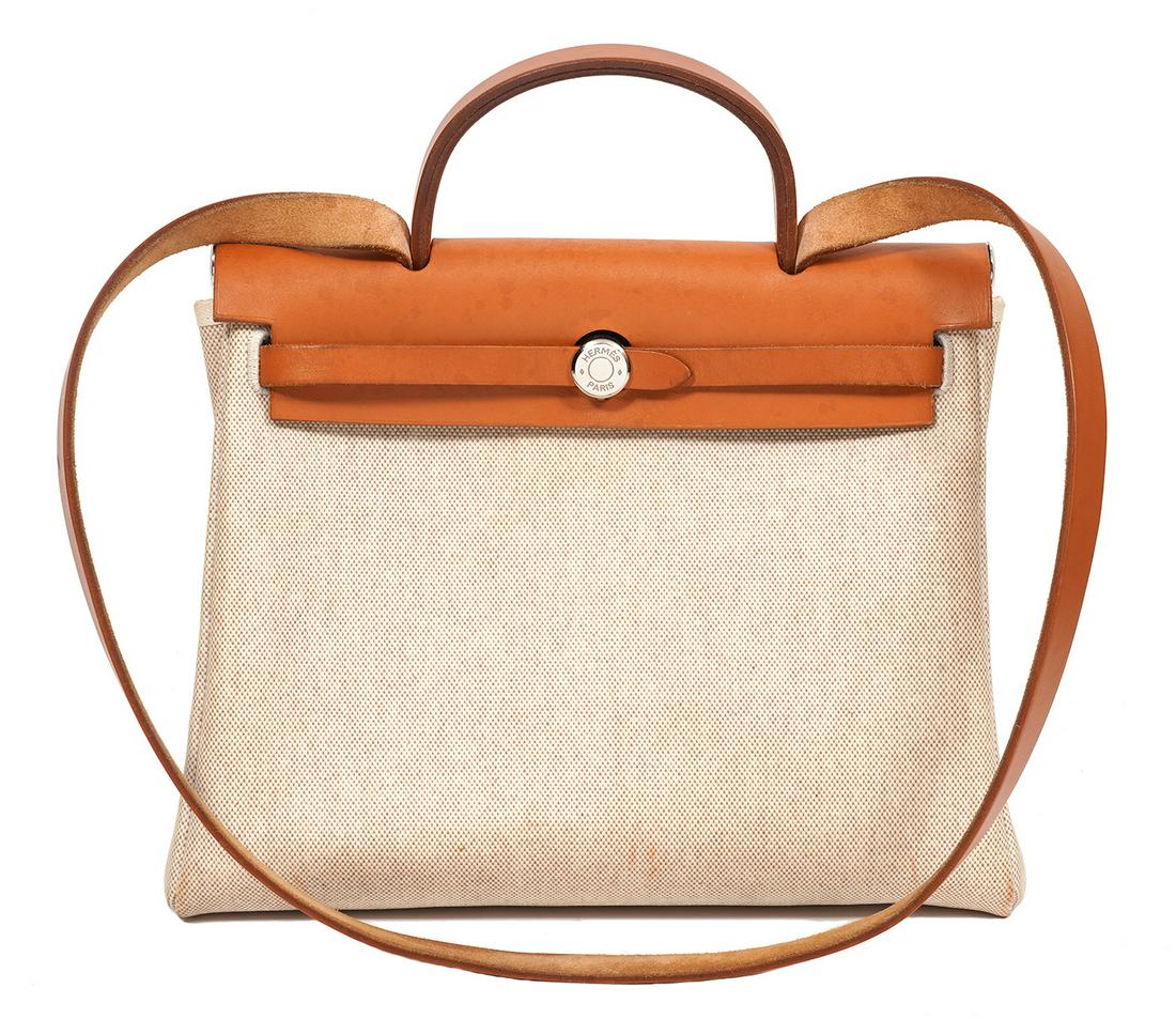 Hermes Beige Toile Herbag MM 2000: Hermes Herbag in beige toile with leather flap, trim and strap accented with palladium finished hardware. 2 in one bag - leather moves to black smaller body bag included. 39cmL x 31cmH x 15W cm. Made