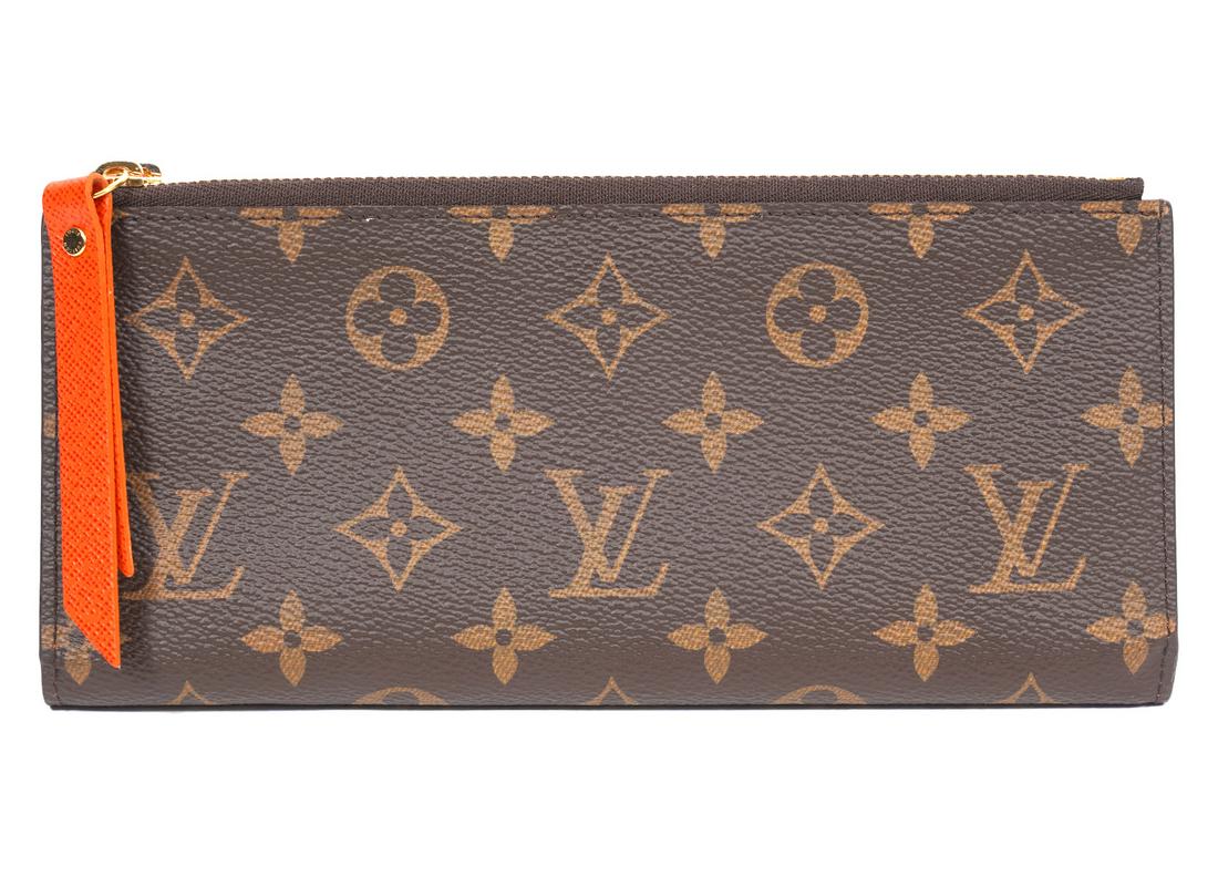 Louis Vuitton Monogram Adele Wallet: Louis Vuitton monogram Adele wallet featuring a fold in half design, 12 credit card slots, 2 bill slots and 2 full length zipper pockets. Lined in Chili red (orange) with matching zipper pulls. 8/5"L