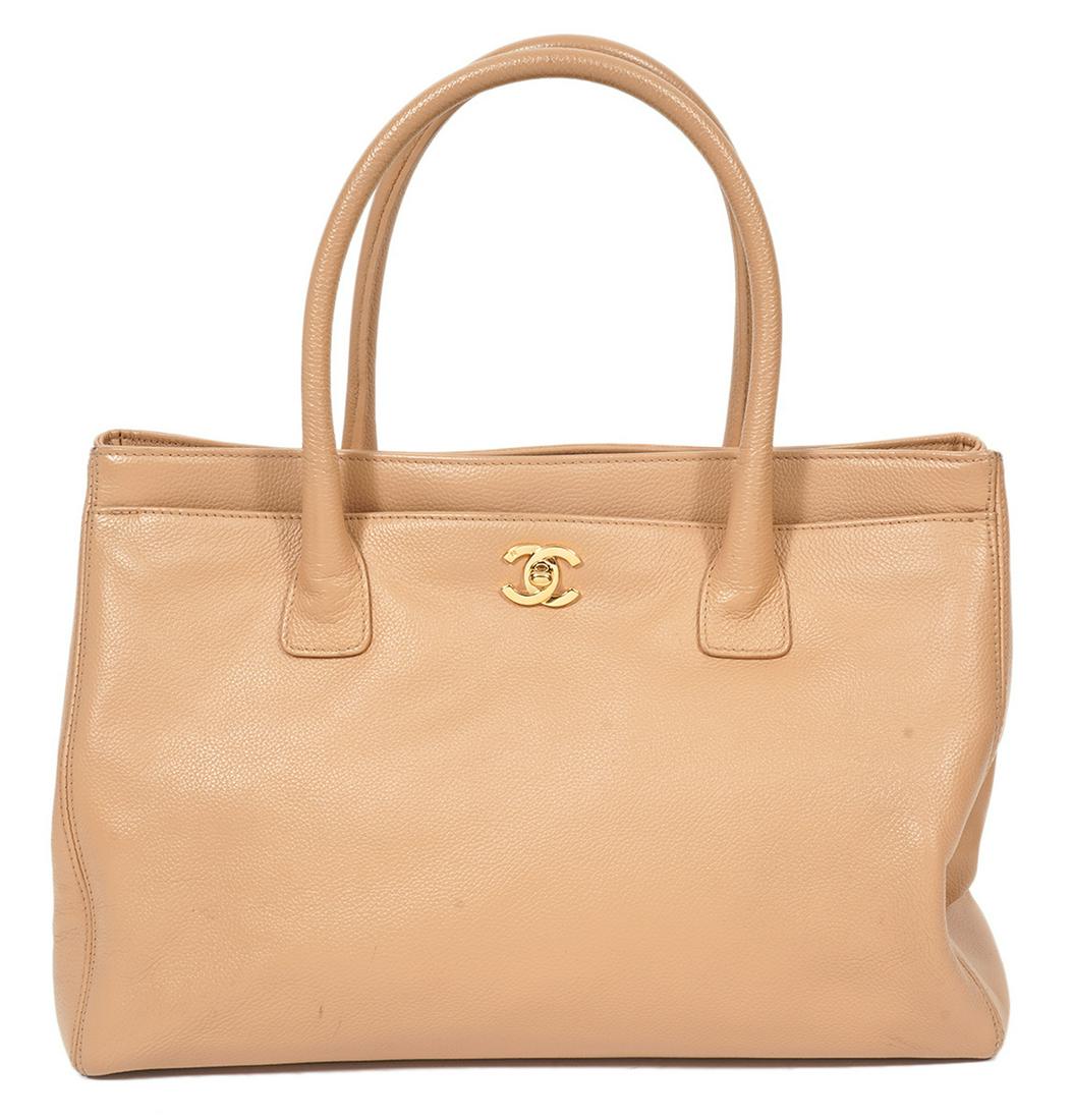 Chanel Beige Leather Tote 2004: Chanel beige leather tote featuring full length front and back outer pockets, rolled handles, a gold tone CC turn lock front closure and 2 inner snap closures. Lined in tonal fabric with a long zipper
