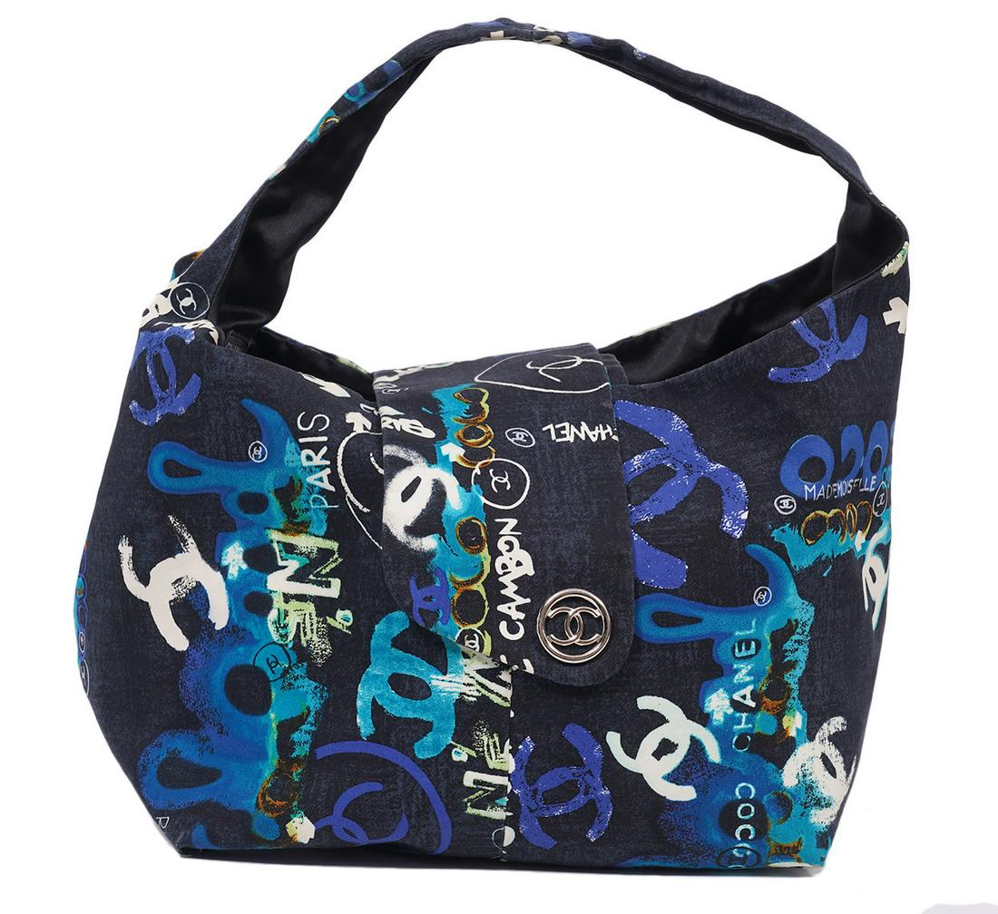 Chanel Limited Edition Printed Shoulder Bag: Chanel limited edition printed shoulder bag in black, white, blue and turquoise with fabric flap closures accented with a silver tone CC. The playful prints says Coco, Mademoiselle, CC, Paris, Rue Cab