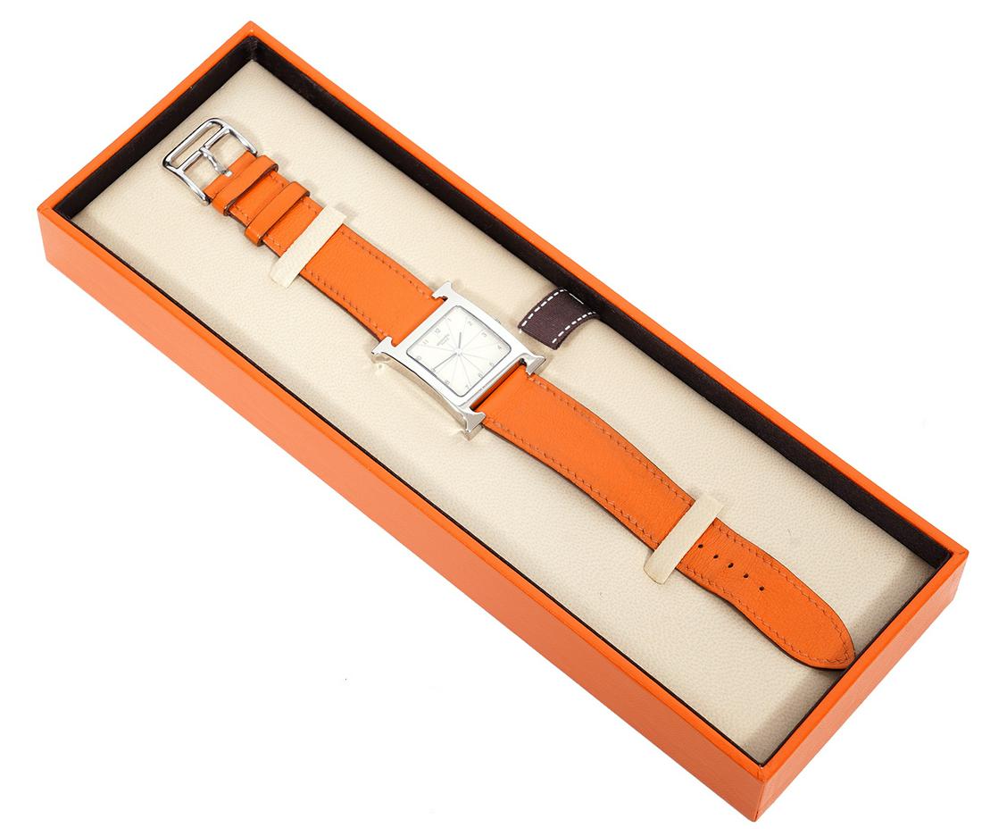 Hermes Heure H Leather Band Watch: Hermes Heure watch with iconic orange leather band and palladium finished H shaped watch and buckle. Band adjustable from 6.5" - 7.5"L. HH1 510. Case size: 23mm. Serial number 1673362. In original box