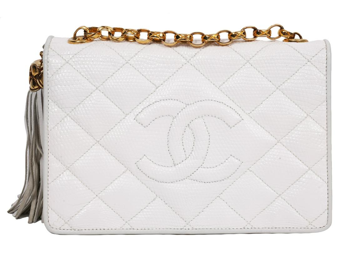 Chanel White Snakeskin Flap Bag Bijoux 1989: Chanel vintage white snakeskin small flap bag featuring large stitched CC front, large leather tassel and gold tone bijoux chain. Lined is smooth white leather with a zipper pocket inside. 7.75"L x 5"