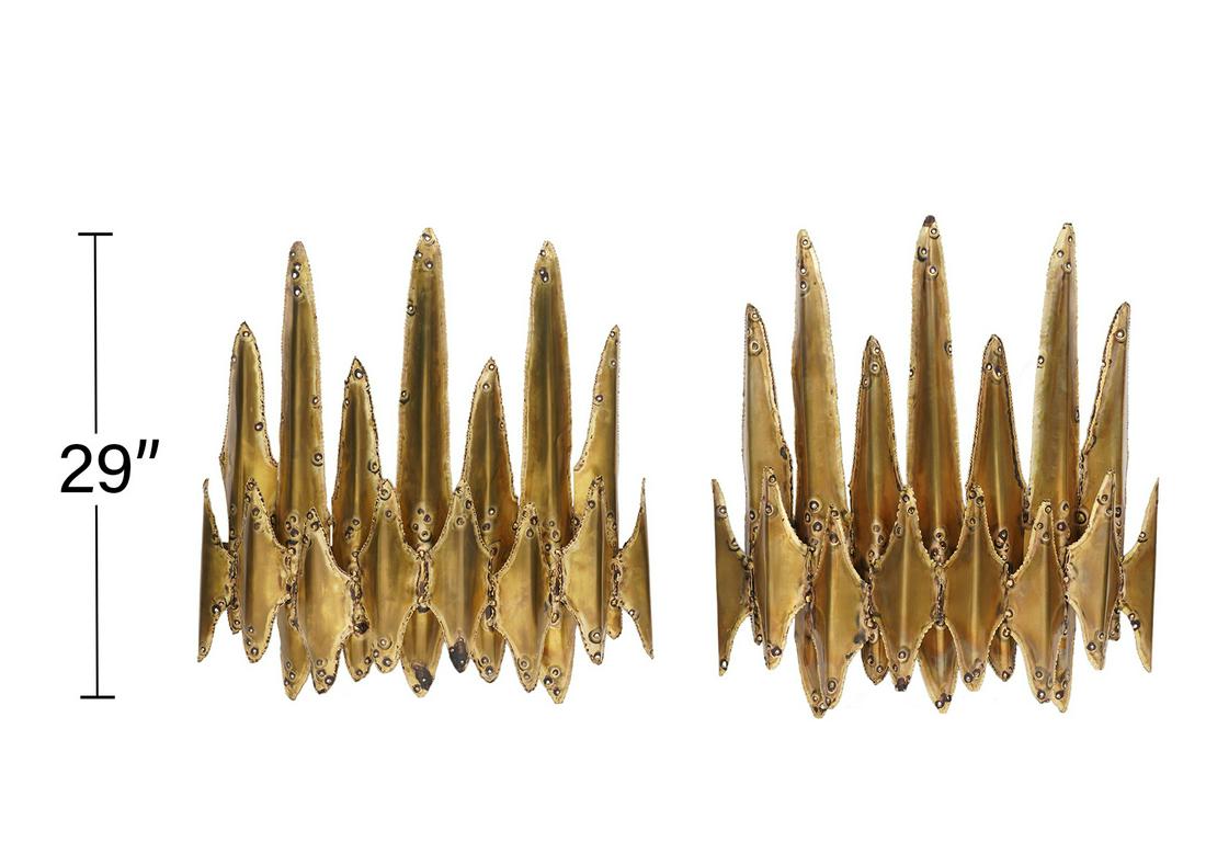 Pr. Tom Greene Brutalist Brass Wall Sconces: Pair of large brutalist brass wall sconces by Tom Greene for Feldman Lighting Co. Torch cut, patinated brass 2 light wall sconces with Feldman label on backside. Measures 29"H x 29:W x 7.5"D. Conditio