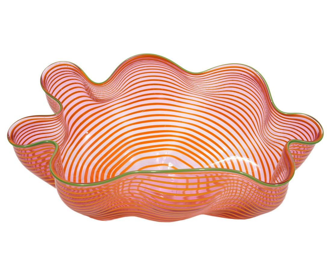 Dale Chihuly Lip Wrap Hand Blown Glass Bowl: Dale Chihuly, American (Born 1941). Green lip wrap on wavy rippled bowl with tangerine horizontal lines. Signed and dated on bottom, 'Chihuly '92'. Measures 9.5"L x 5"W x 5"H. Condition report: good c