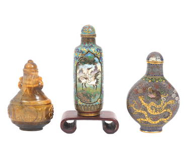 3 Chinese Snuff Bottles: 3 Chinese snuff bottles include a carved gold tone glass snuff bottle with small handles on the shoulders. Measures 2.5"H x 1.5"L x 7/8"W. Cylindrical Chinese cloisonne snuff bottle features birds on