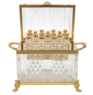 Baccarat Style Cut Crystal & Brass Perfume Casket: Baccarat style diamond cut crystal casket with dome lid and brass banding, side handles and hinged back. Inside are 9 cylindrical perfume bottles with decorative brass tops. Casket is mounted on