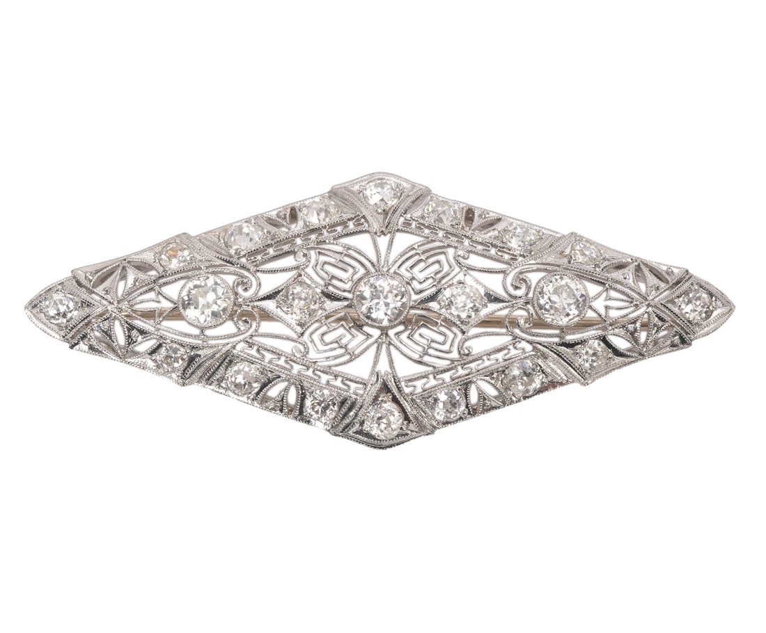 Art Deco Antique Diamond Filigree Platinum Brooch: Antique art deco diamond and platinum filigree brooch showcasing a novette shaped design highlighting 3 approx. .33ct each collet-set old European cut diamonds (H-SI-I) in a delicate open work motif f