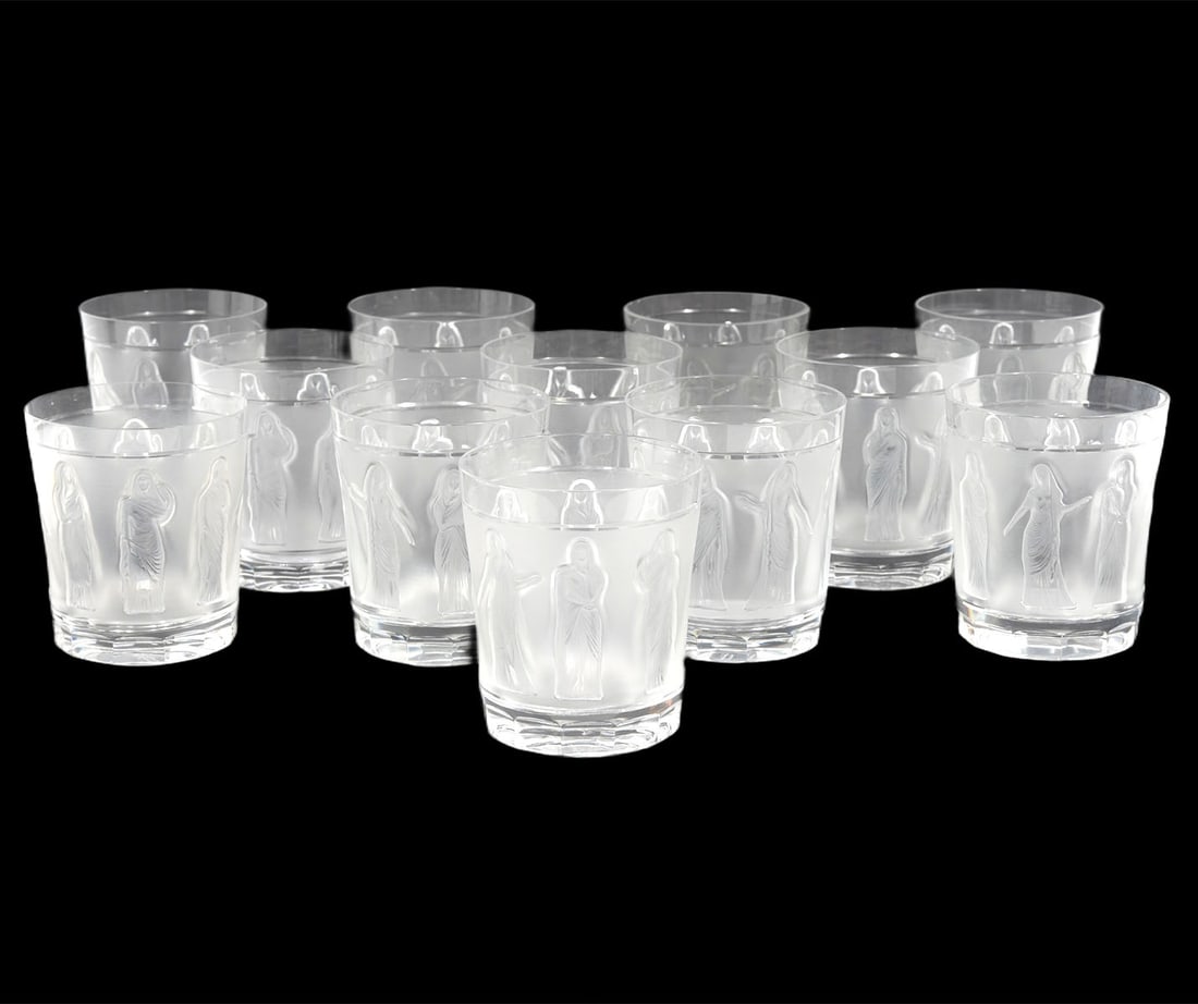12 Lalique Crystal 'Femmes Antique Tumblers': 12 Lalique crystal 'Femme Antique Tumblers' have women's figures around the sides and are etched 'Lalique France' on bottoms. Measures 4"H x 3.5"W. Condition: good condition, no issues, please see all