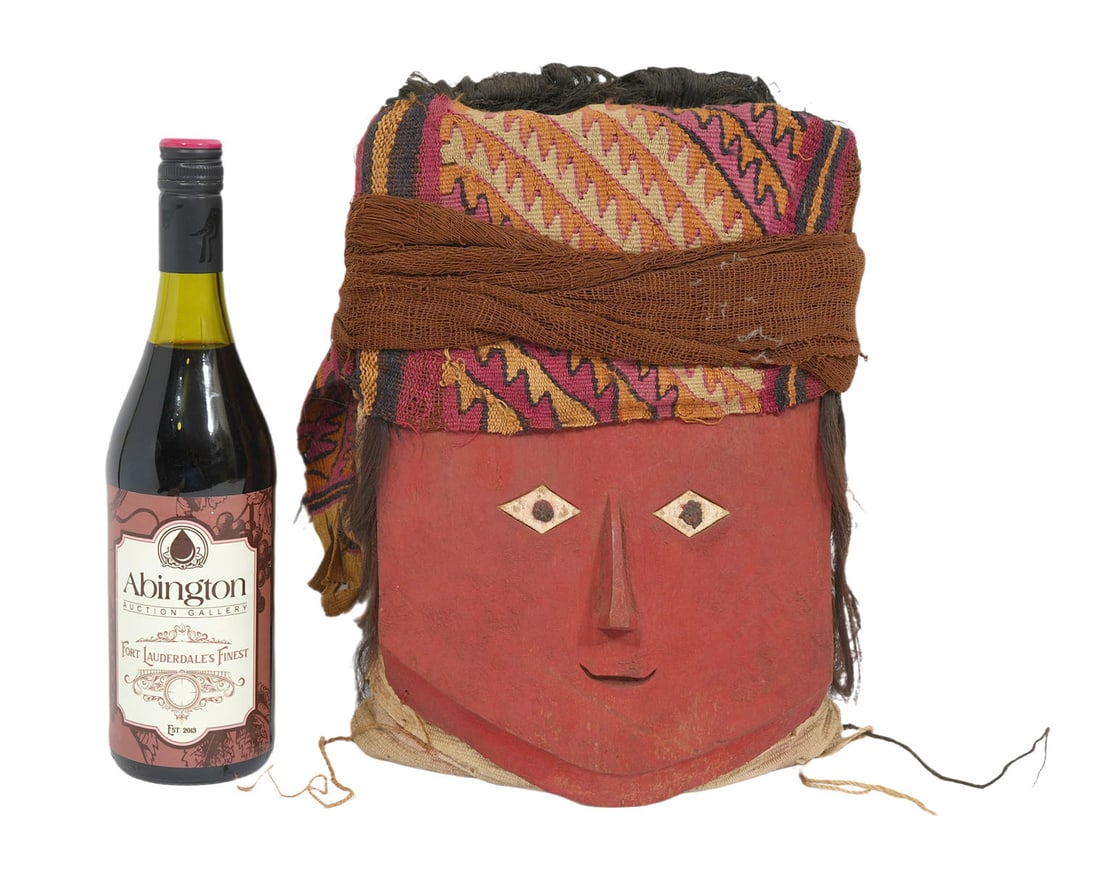 Peruvian Wood Mask with Headdress- Andre Emmerich: Peruvian wood mask is painted red, black and white with textile headdress is attached to votive bundle. According to description by Andre Emmerich Inc. Gallery, this is from the Chancay Central Coast,
