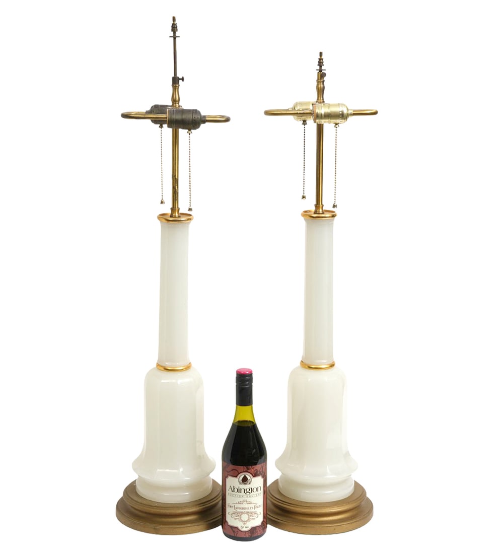 Pair Vintage Opaline Glass Table Lamps: Pair of vintage opaline 1950's table lamps have white glass bodies with gold accents and are mounted on circular bronze colored wood bases. Both lamps have 2 sockets with pull chains. Measures 32.25"H