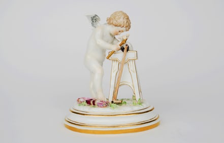A Meissen Porcelain Sculpture Of A Cupid Sharpening An Arrow
