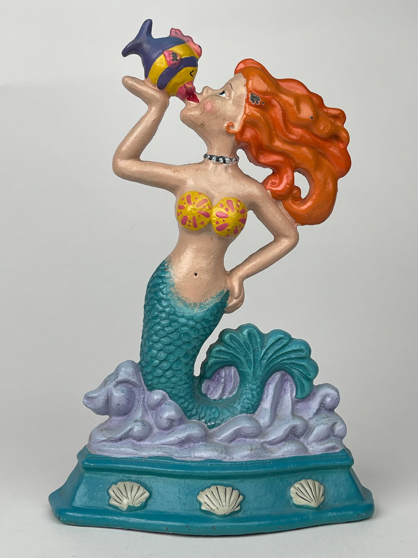 A Cast Iron Orange Hair Mermaid Kissing Fish Doorstop: A Cast Iron Orange Hair Mermaid Kissing Fish Doorstop. H: 9-1/8”W:6-1/4”