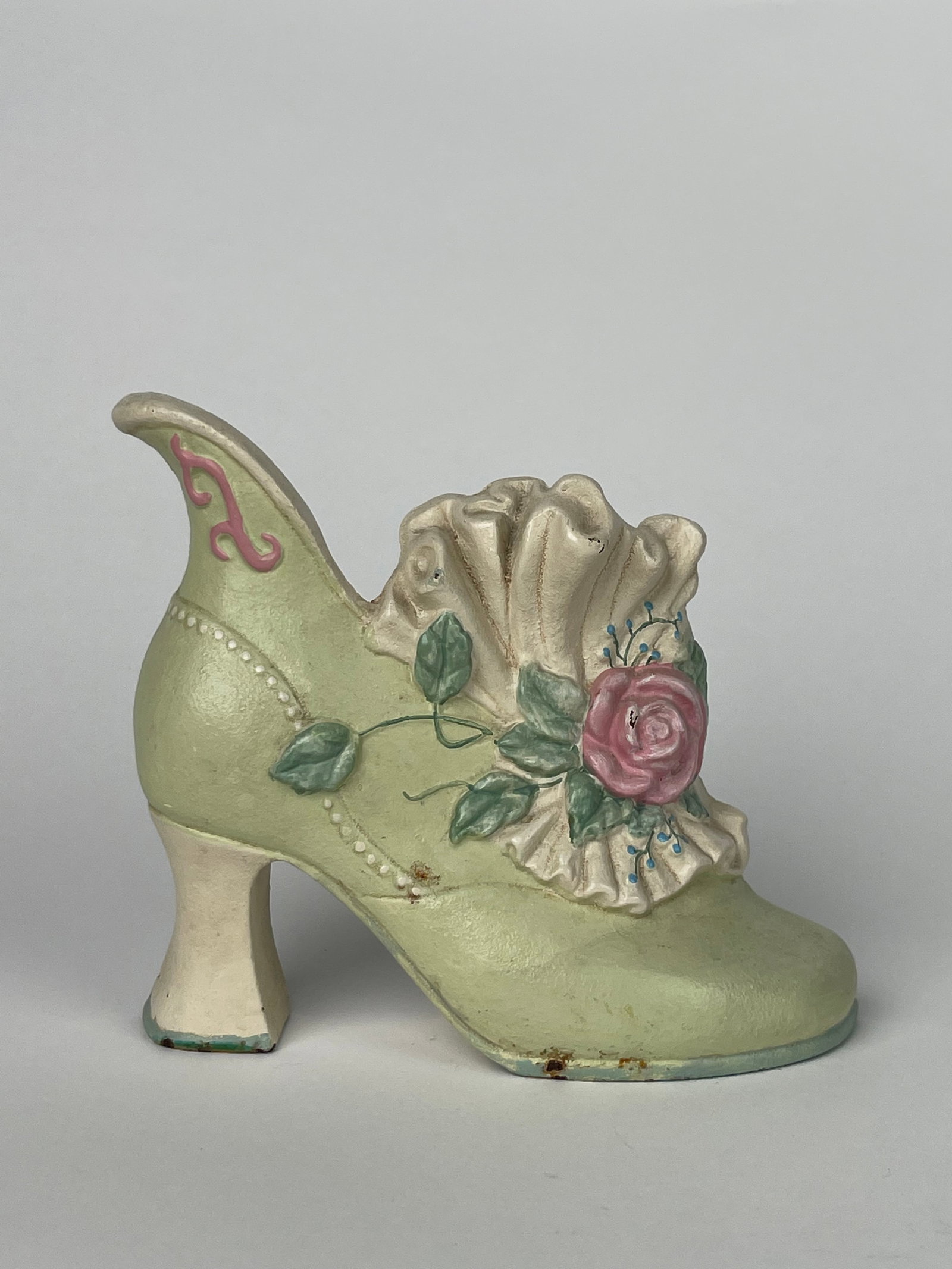 A Light Green Ladies Heel Cut Iron Doorstop with A Pink Rose & White Ruffle: A Light Green Ladies Heel Cut Iron Doorstop with A Pink Rose & White Ruffle. H: 5-1/8” W:6”