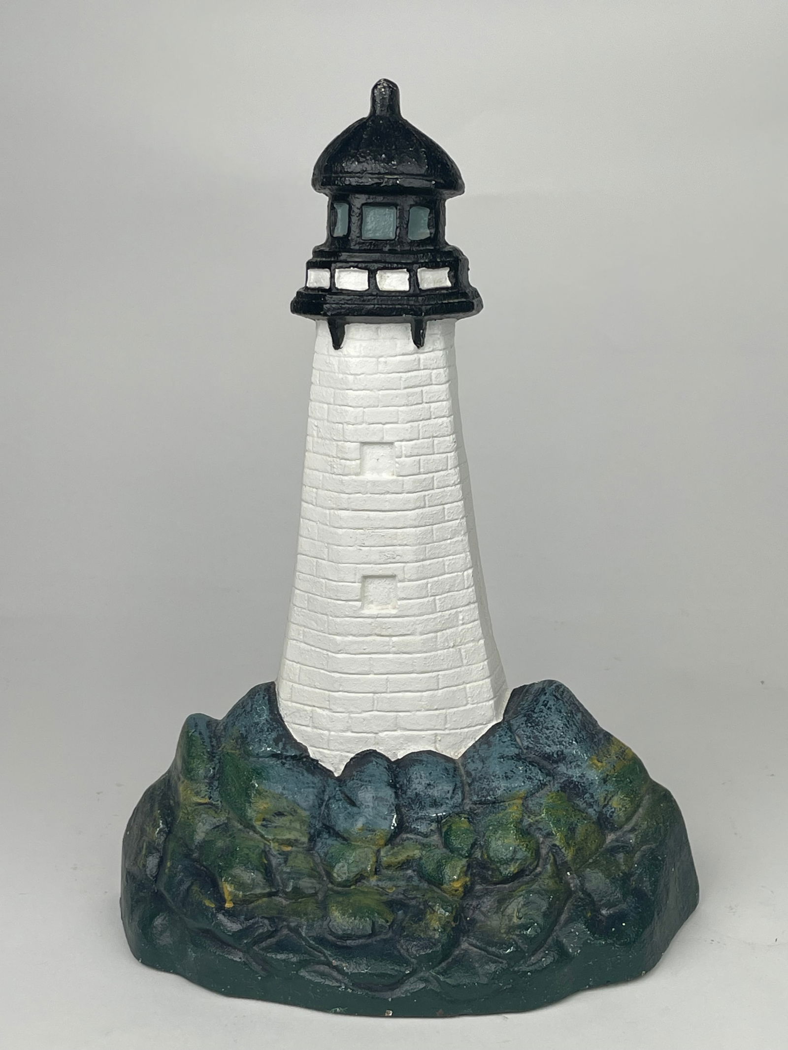 A Tall Cast Iron Lighthouse Doorstop: A Tall Cast Iron Lighthouse Doorstop. H:14-1/4” W: 10-3/8”