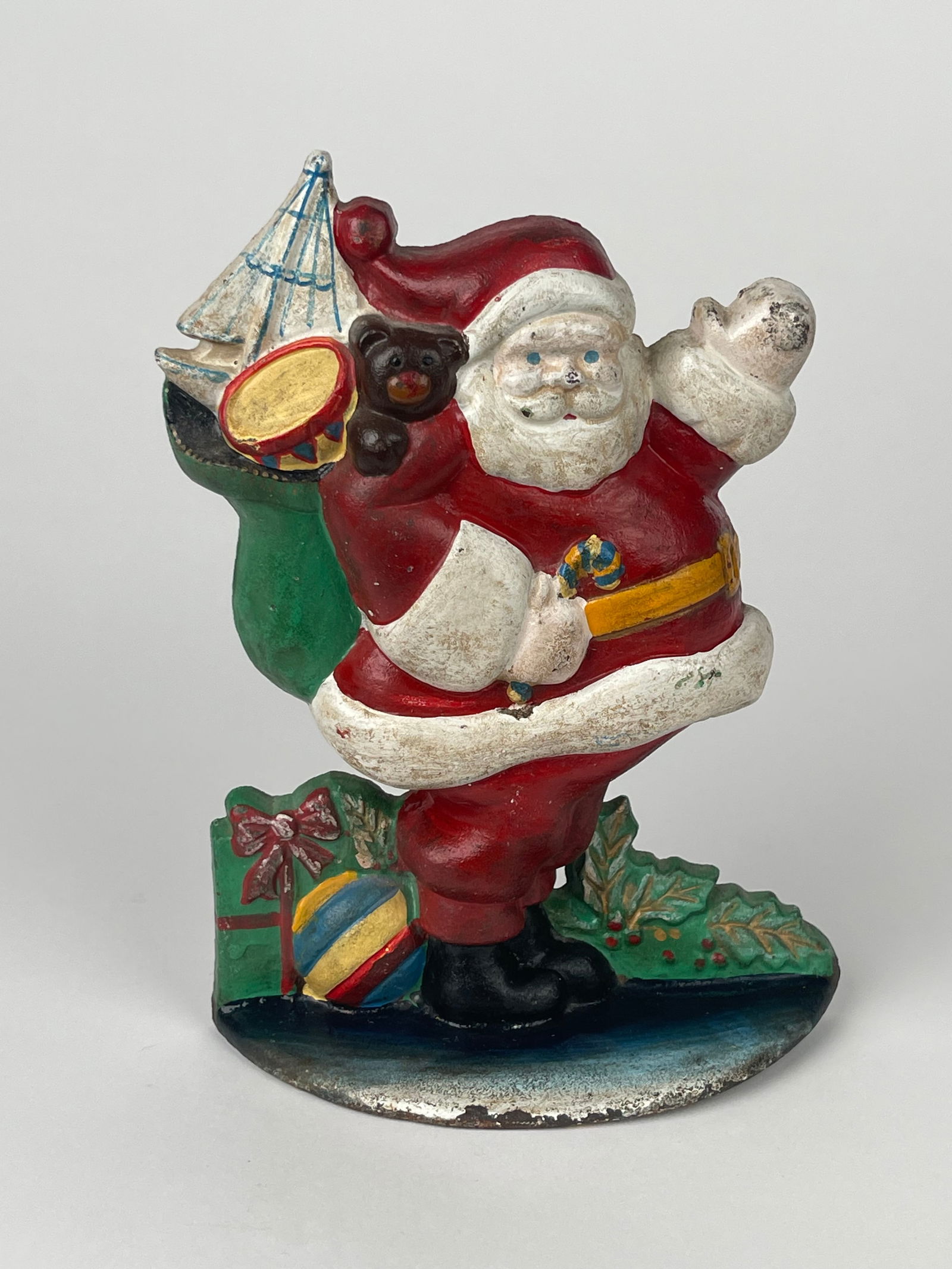 A Cast Iron Santa Claus with Gifts Doorstop: A Cast Iron Santa Claus with Gifts Doorstop. H: 9” W: 6-1/2