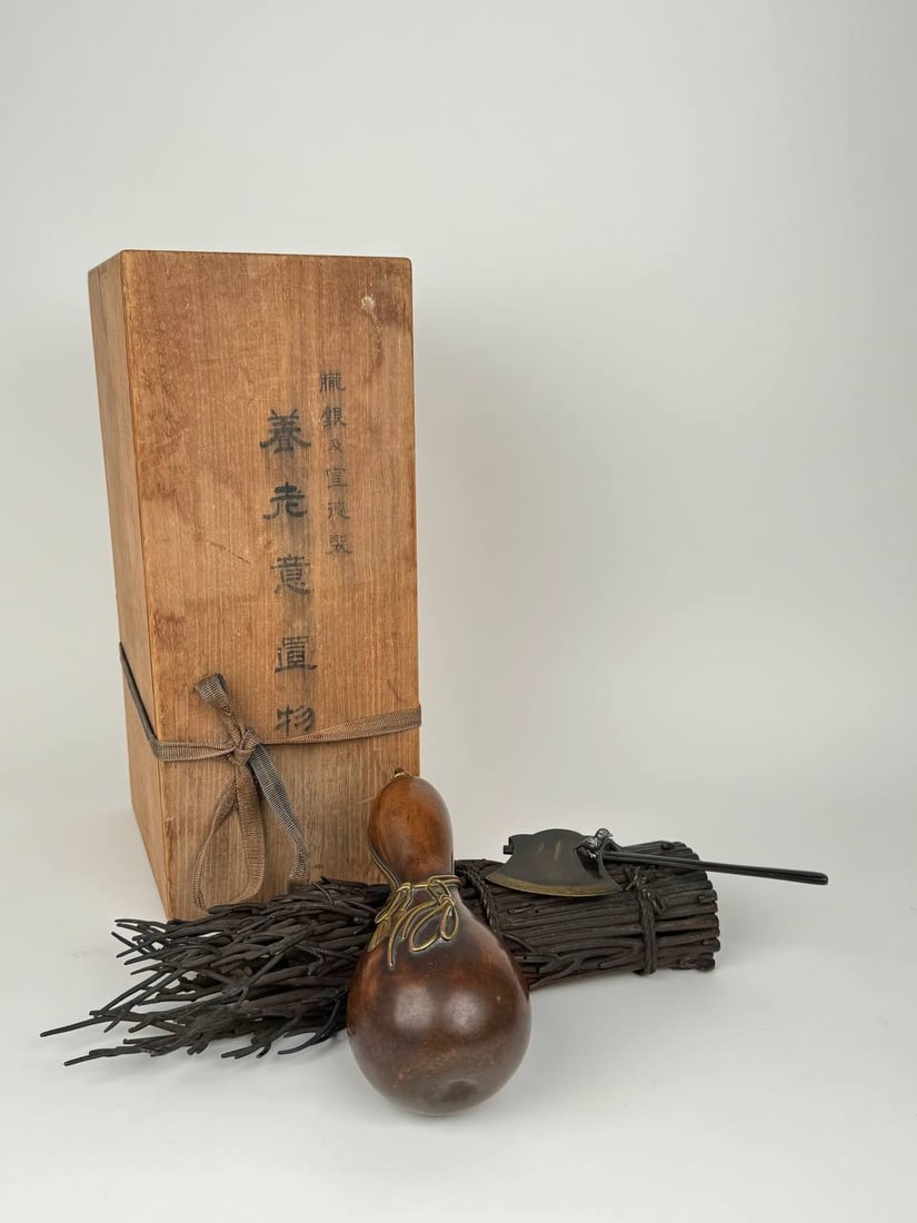 Japanese Meiji Period Patinated Bronze Sculpture: Japanese Meiji Period patinated bronze sculpture of a water flask and an axe set on a bundle of branches, with a Silver bird resting on the axe comes in its original Box. Circa 1890-1900. Artist's