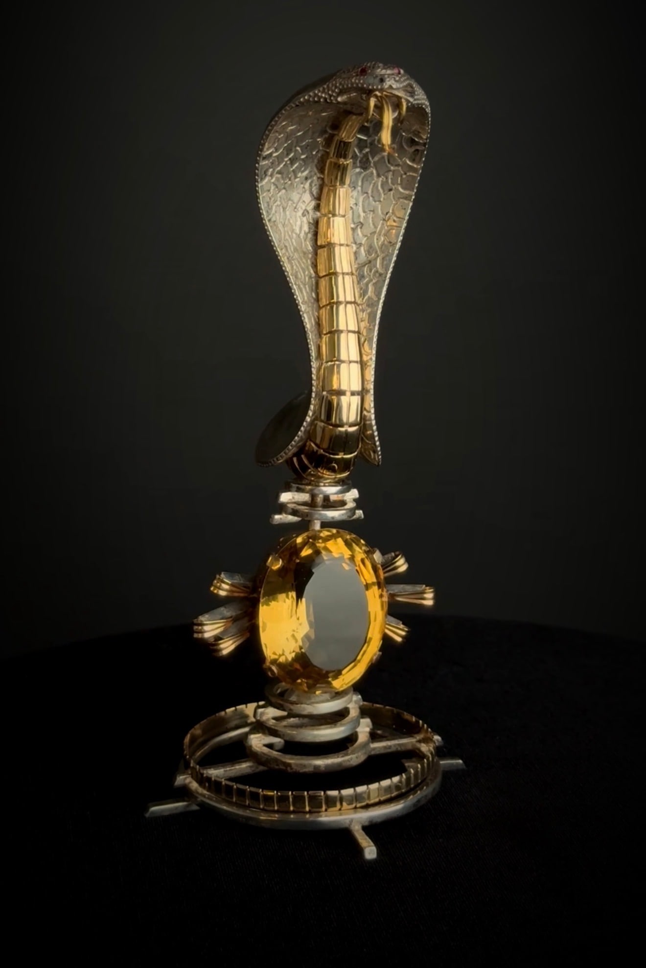 A Cartier Gold, Silver, Ruby & Citrine Serpend Sculpture Design Attr. To Dali: A regal creation by Cartier, circa 1900, crafted for an Indian Maharajah with a passion for exceptional jewels. This striking 14-karat yellow gold and silver cobra, with hypnotic ruby eyes and a lumin