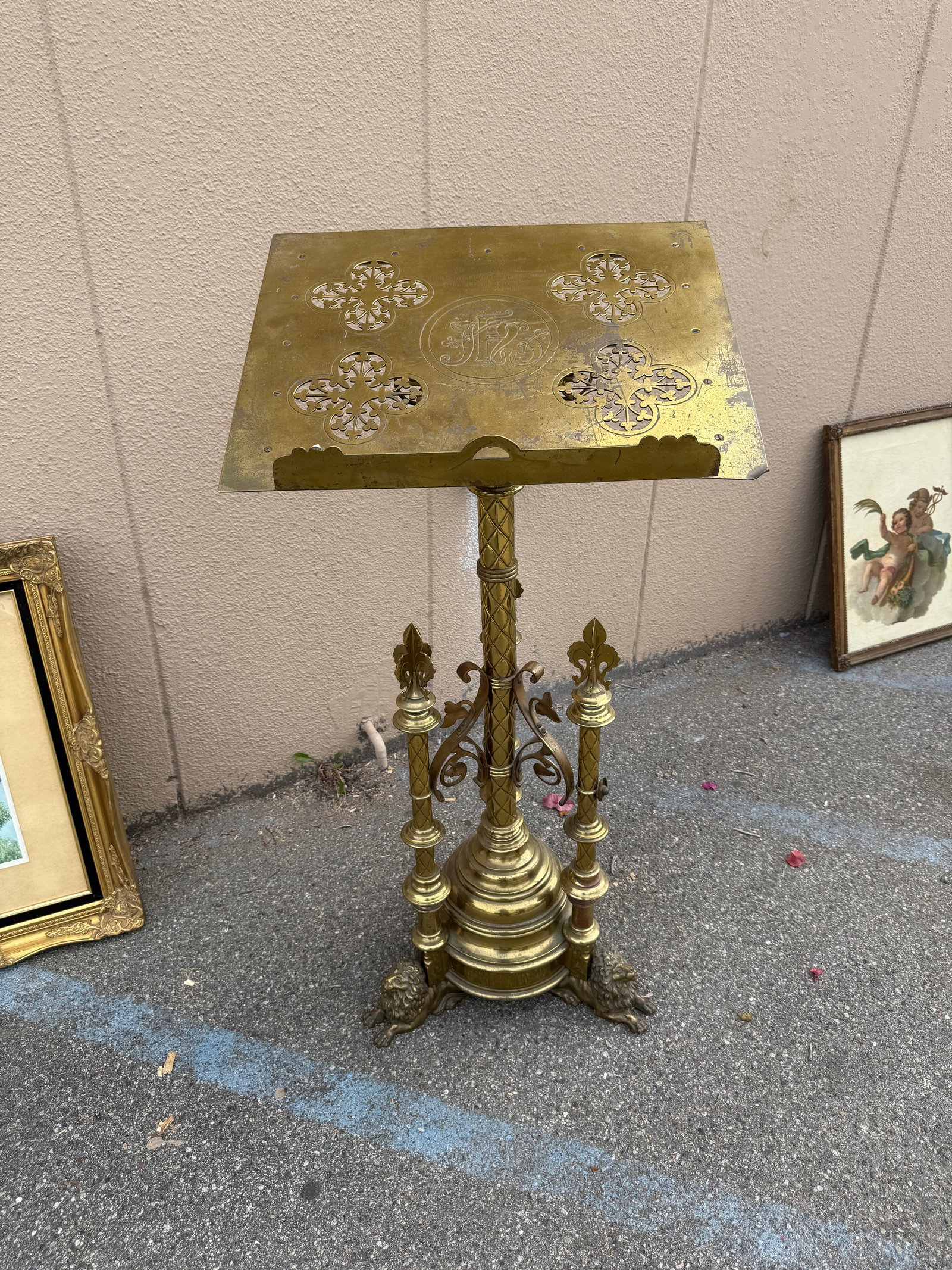Antique Brass Church Lectern with Lion Feet: Ornate brass lectern has a slanted book rest with four quatrefoil cut-outs and a central engraved monogram. The stand is constructed from polished brass with a diamond-patterned central column and
