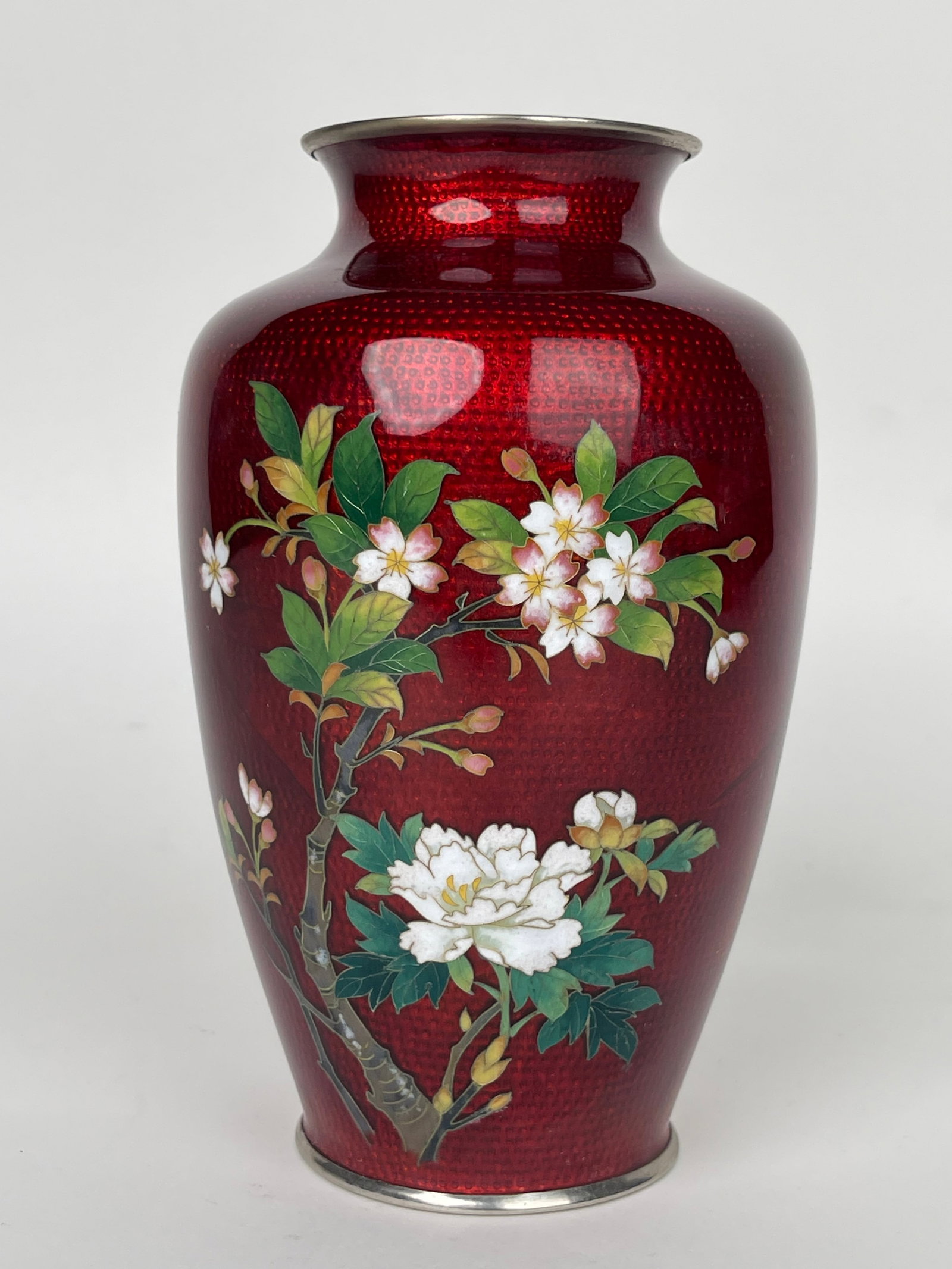A Japanese Red Ground Enamel Vase With Blossoms: A Japanese Red Ground Enamel Vase With Blossoms. H: 7” D: 5”