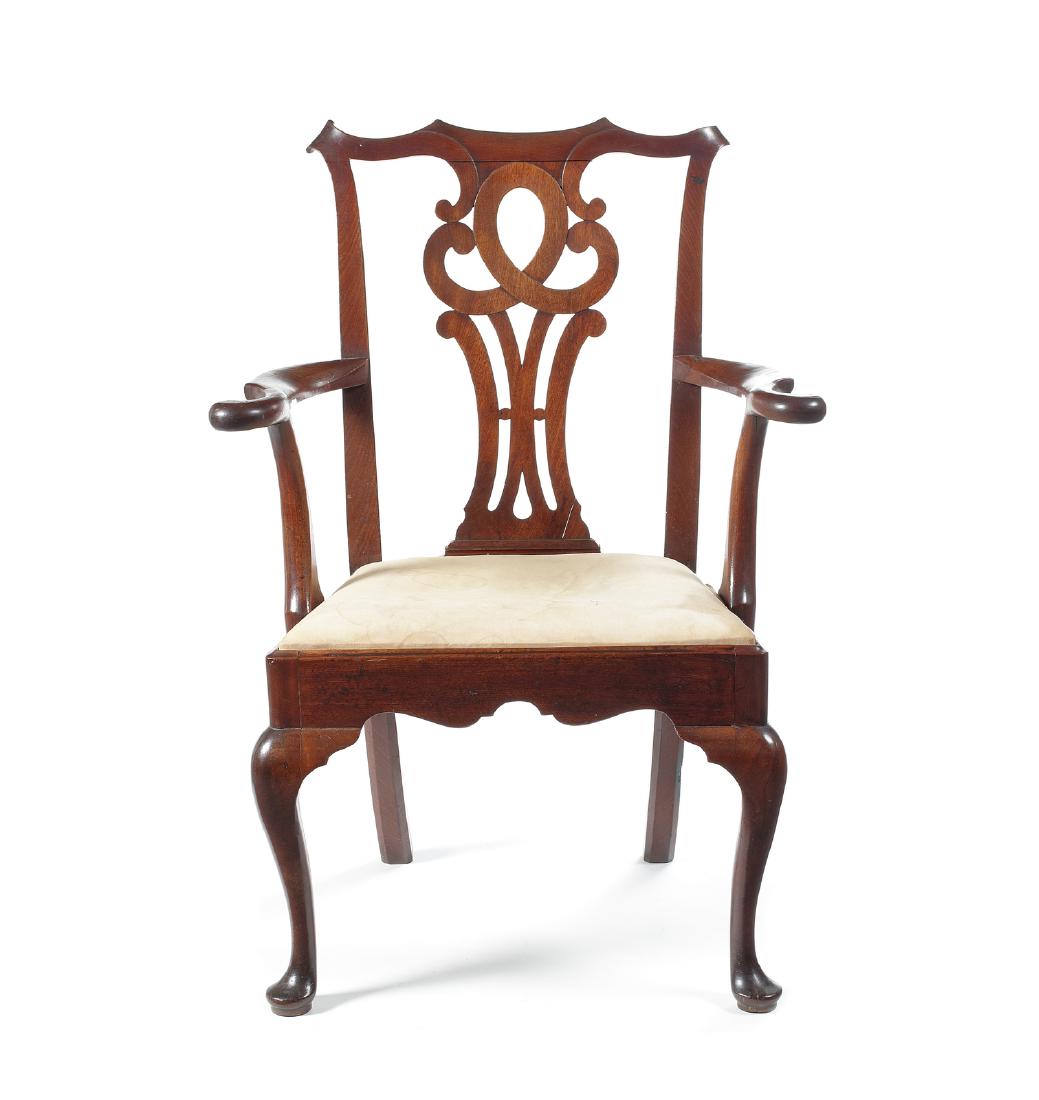 A George III mahogany open armchair: A George III mahogany open armchair in the manner of Thomas Chippendale The scrolled toprail above a pierced scrolling splat and outswept scroll arms above a drop-in seat on cabriole