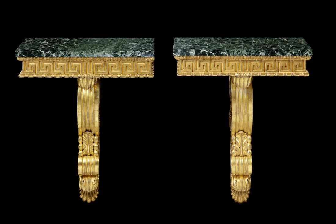 A pair of carved giltwood console tables/brackets: A pair of carved giltwood console tables/brackets Each with a rectangular verde antico marble top above a beaded and leaf carved edge on a double volute scroll anthemion carved support, 19th century a