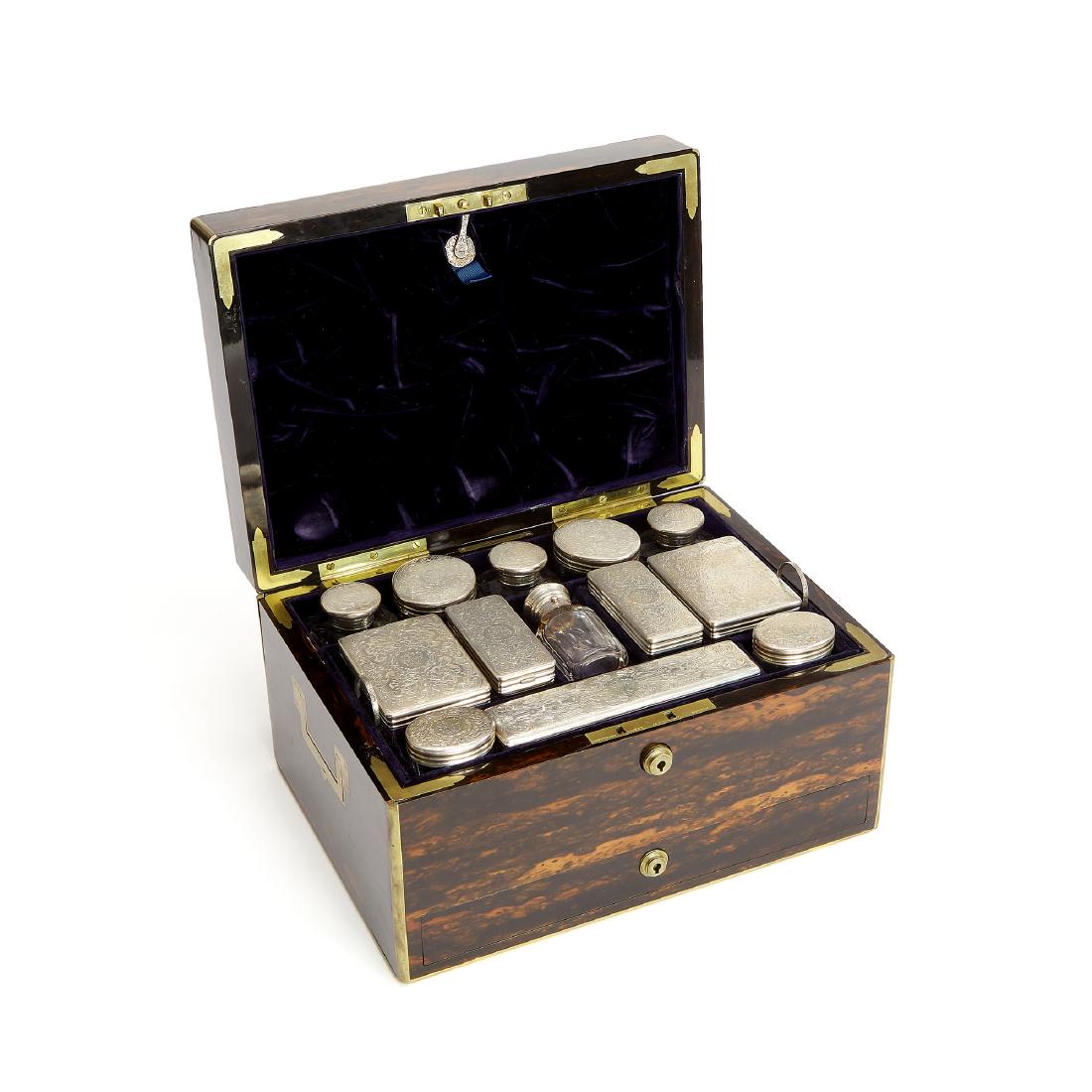 Victorian coromandel and silver fitted box: A mid Victorian coromandel and brass bound dressing box with silver fittings, the box retailed by Leuchars of Piccadilly, the silver fittings by Thomas Johnson, London 1859 The rectangular hinged cove