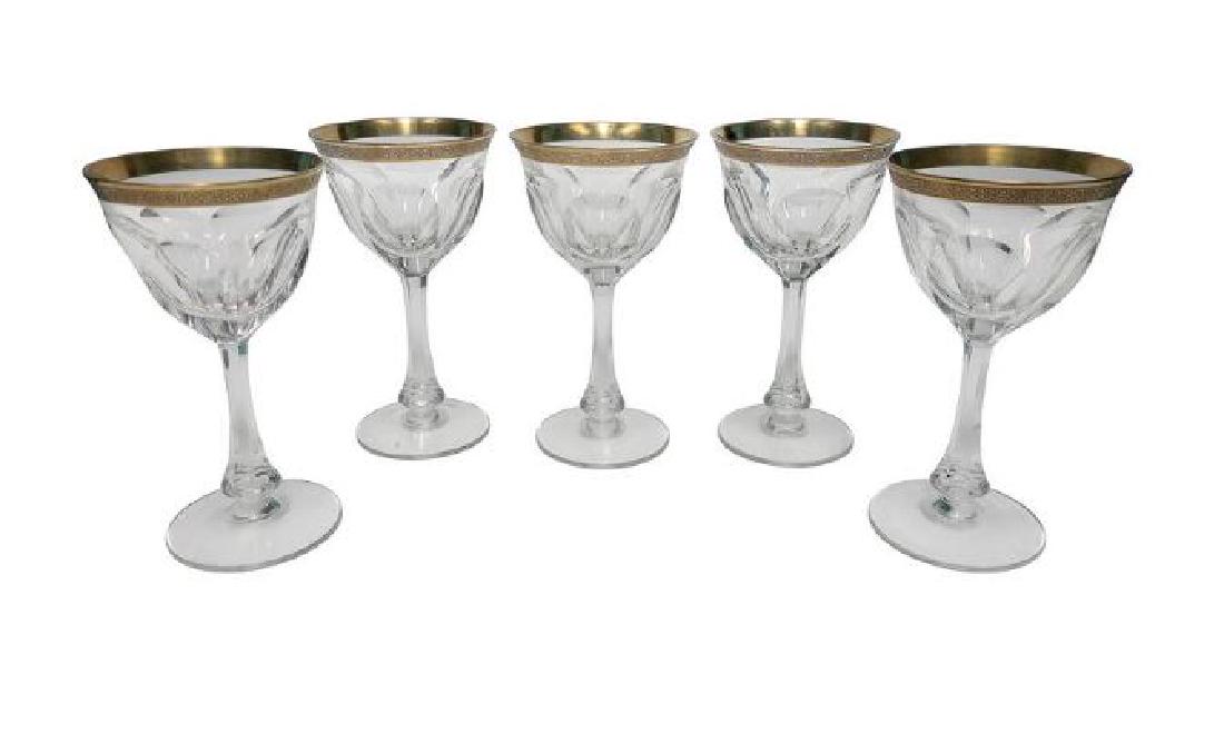 Gold Gilded Crystal Wine Glasses after Baccarat: Set of five faceted substantial crystal glass wine or water goblets with a heavy gold embossed decorative gilded rim, in the style of Baccarat, circa Early to Mid-Century 20th Century. Each measure 7 