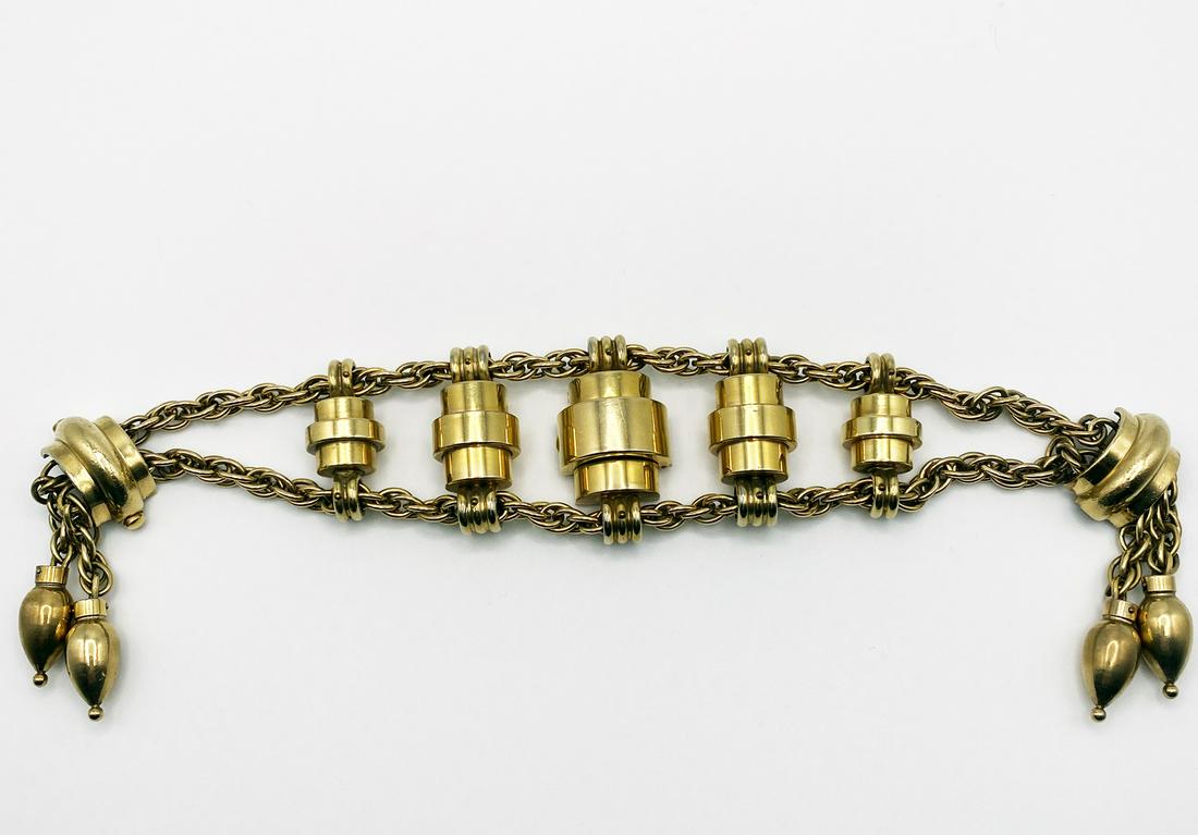 Vintage Wristwatch Bracelet: Wristwatch bracelet in gold metal. Bold design, of 5 gradient capsules in between of two chains, magnetic clasp ending with 4 tassels of chains and oblong shaped gold beads. Watch hidden in the centra