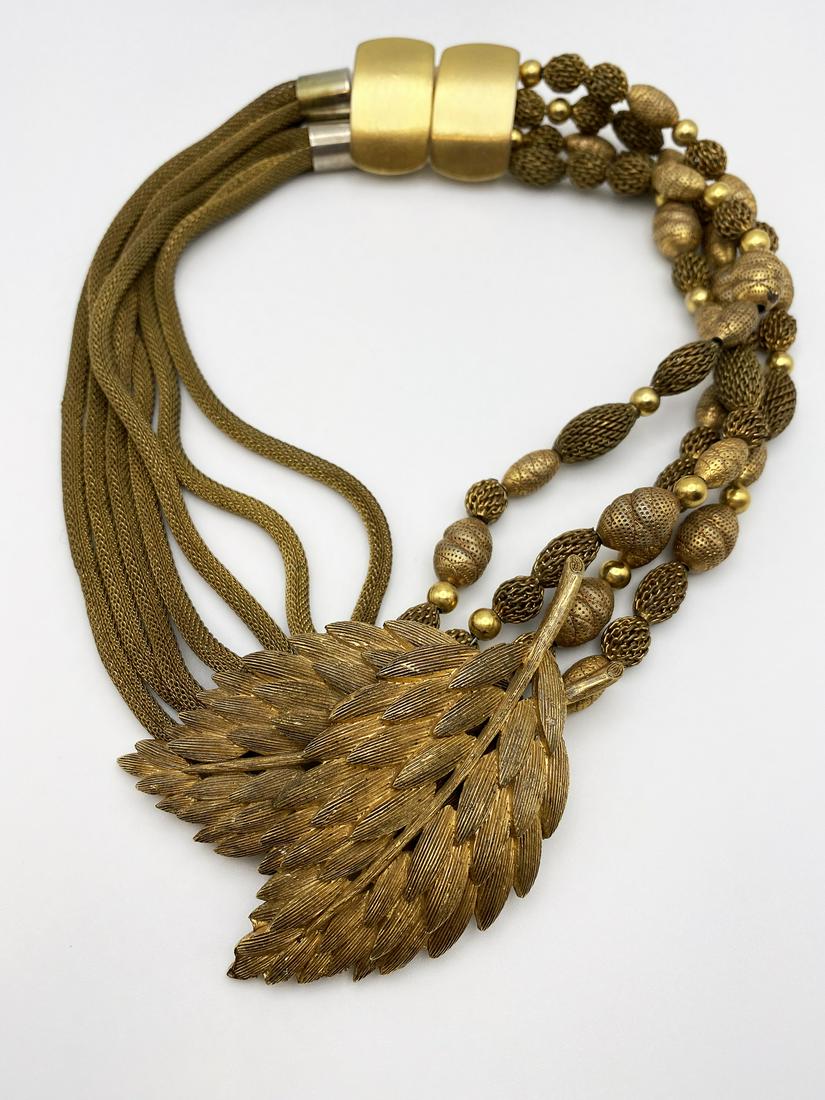 Jay Feinberg Vintage Necklace.: Vintage 1980 collar necklace in gilt-brass. On the right side two sets of 4 mesh tubular chains, on the left side four strands of engraved elaborated beads in gilt-brass, both linked to the central st