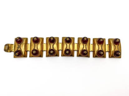 Elsa Schiaparelli Vintage Bracelet: Articulate bracelet in brushed gilt metal and ruby beads. Seven rounded rectangular tiles, with two ruby beads surrounded by an embossed rope design. Tiles connected by articulated finds that simulate