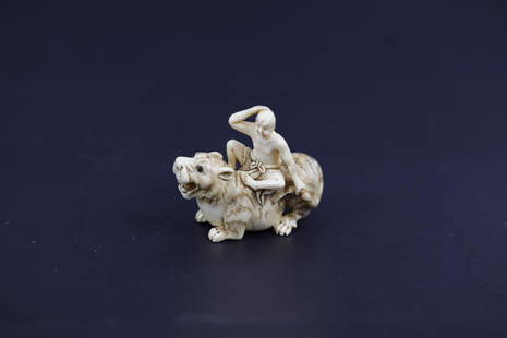 A Carved Netsuke of A Lohan Riding a Tiger with Inlay: A Carved Netsuke of A Lohan Riding a Tiger with Inlay Eyes Signed. H: 1.5 W: 1.5 Inches