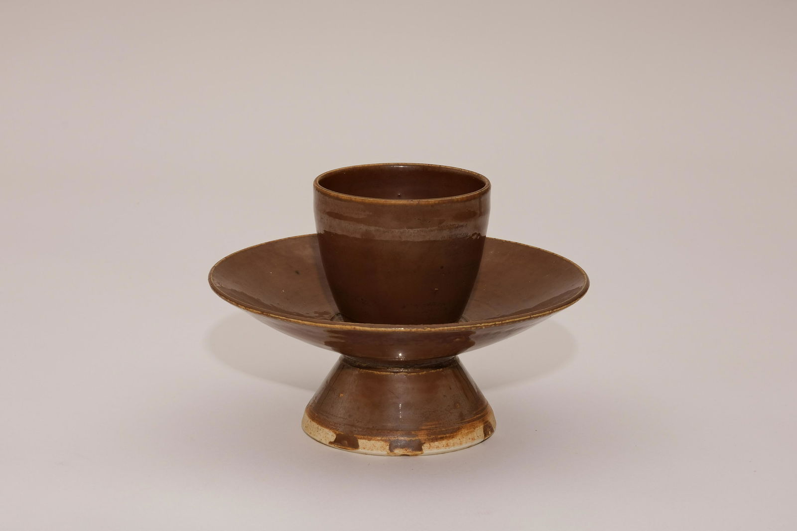 A Ding Ware Brown-Glaze Tea Cup Stand: A Ding Ware Brown-Glaze Tea Cup Stand. H: 4.5 in. (11.5 cm) D: 6.3 in. (16 cm)