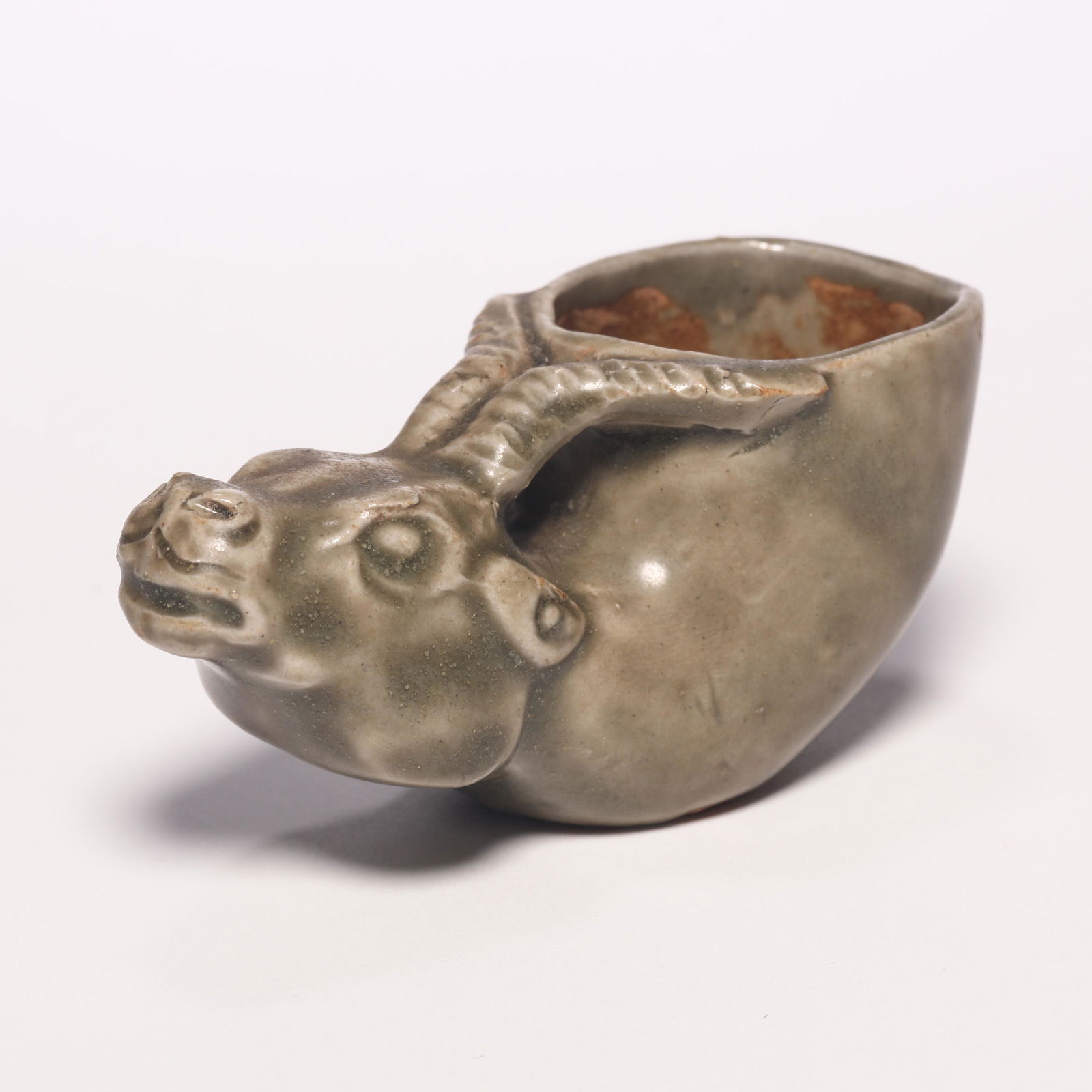 A Celadon Ox-Formed Cup: A Celadon Ox-Formed Cup. H: 1.5 in. (4 cm) W: 3.5 in (9 cm) D: 1.5 in (4 cm)