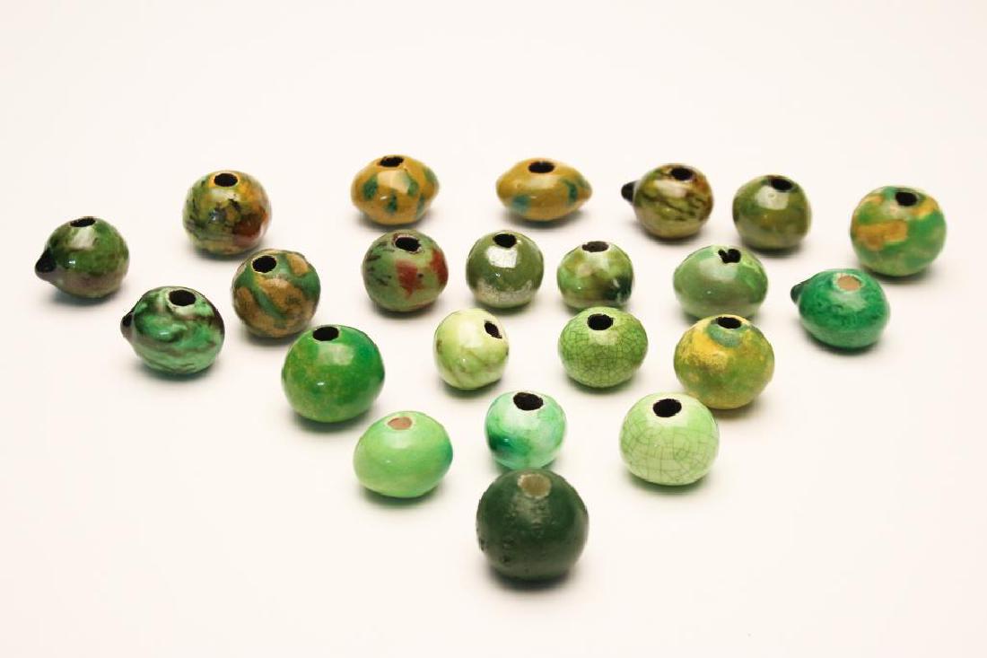 Doyle Lane MCM Studio Pottery Beads, Lime, 22: Group of 22 ceramic beads by Doyle Lane (20th Century, California). Sizes vary between approx. .75 inches and 1.125 inches by .75 inches. Colors very between chartreuse to interesting yellow green swi