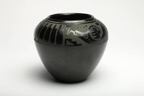 Angel Sanchez San Ildefonso Black Pottery Vase: Angel Sanchez San Ildefonso Black Pottery Vase. Black pottery vase with hand etched decoration, tribal symbols covering the shoulder and upper rim, c. 1960. Incised script signature Angel Sanchez -