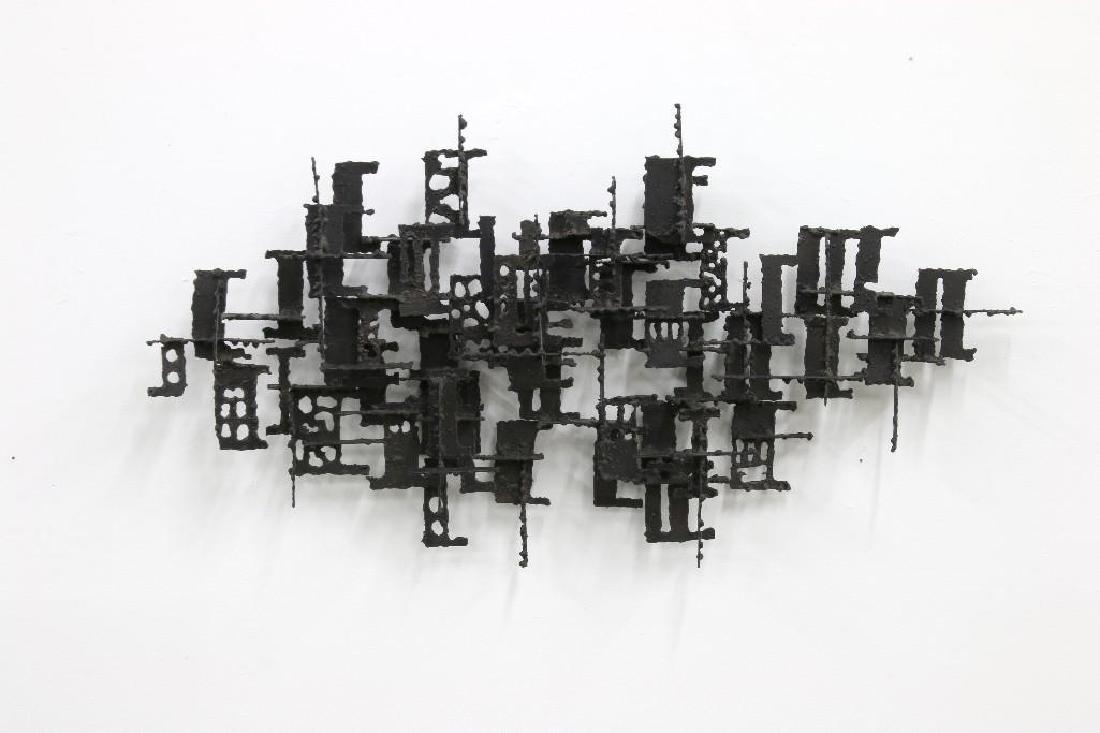 Mid-Century Brutalist Torch Cut Wall Sculpture: In the style of Daniel Gluck. Approx. 20 in H x 38 in W x 5.5 in D.