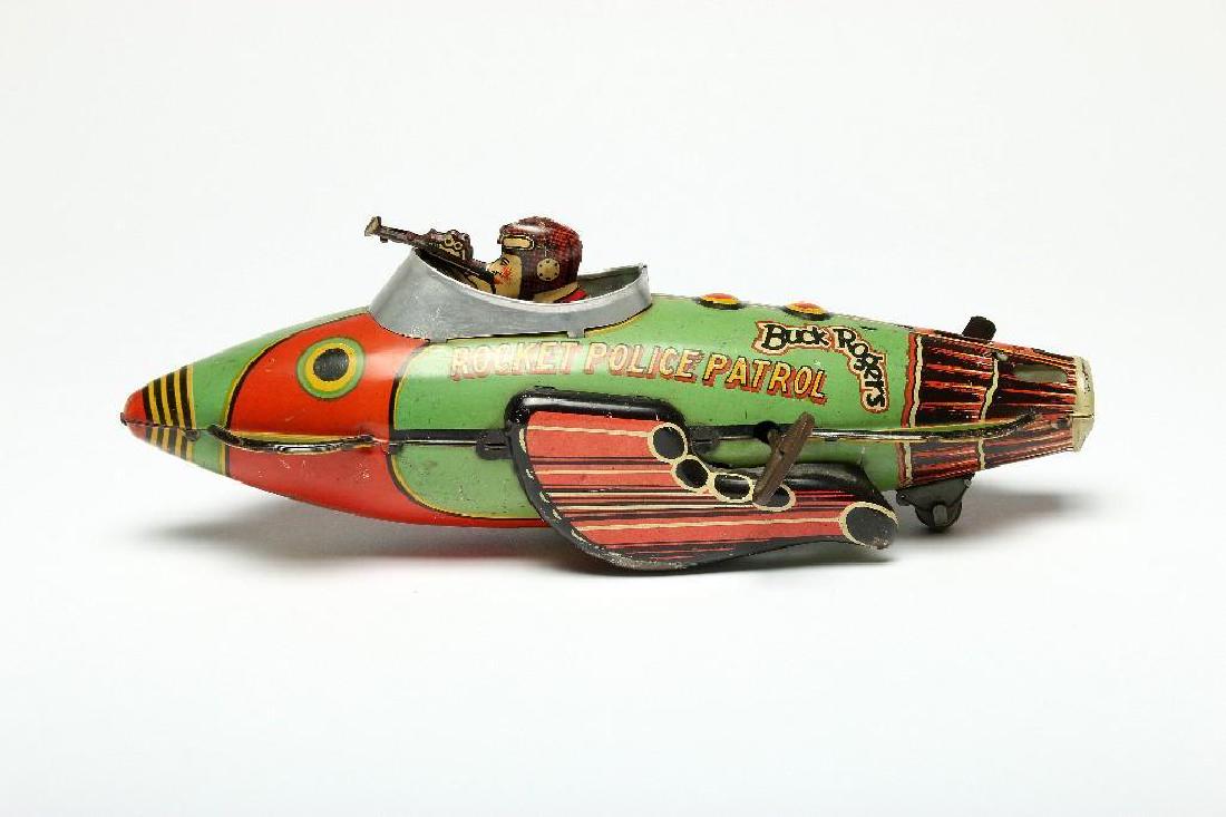 1934 Toy Space Ship Buck Rogers Rocket Police Patrol: Approx. 12.5 in W x 4.5 in H x 4 in D. Toy produced in 1934 as merchandise for Buck Rogers, the popular space-based adventure series.