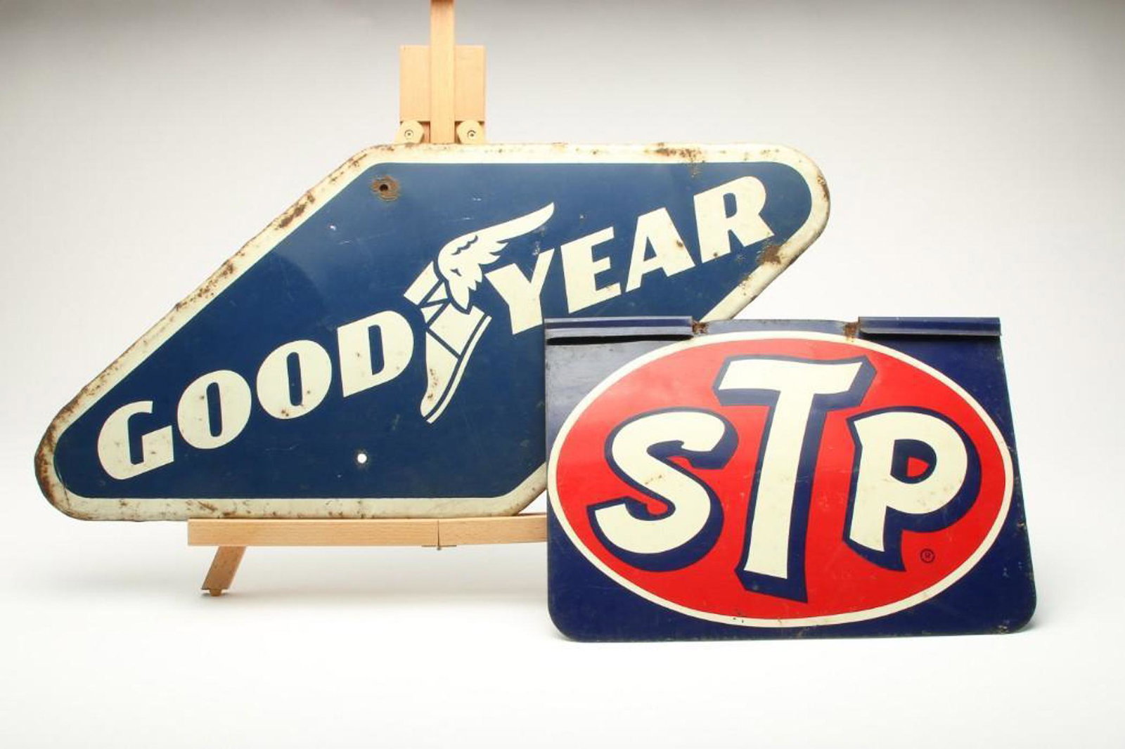 Group of 2 Vintage Tin Litho Signs Goodyear STP: Goodyear Sign 28 x 13 in. Single sided, 1960s. STP Double sided flange Sign 15.5 x 11 in.