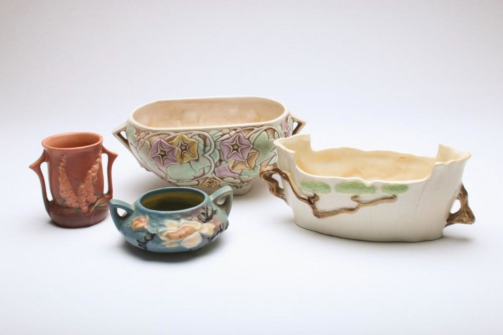 Group of 4 Roseville Pottery Ming Tree Morning Glory: Morning glory planter approx. 4.5 in H x 11.5 in W x 6.5 in D.; Ming tree planter 4.5 in H x 10 in W x 5.25 in D; Fox glove 4.25 in H; Magnolia 2.25 in H x 6 in Dia.