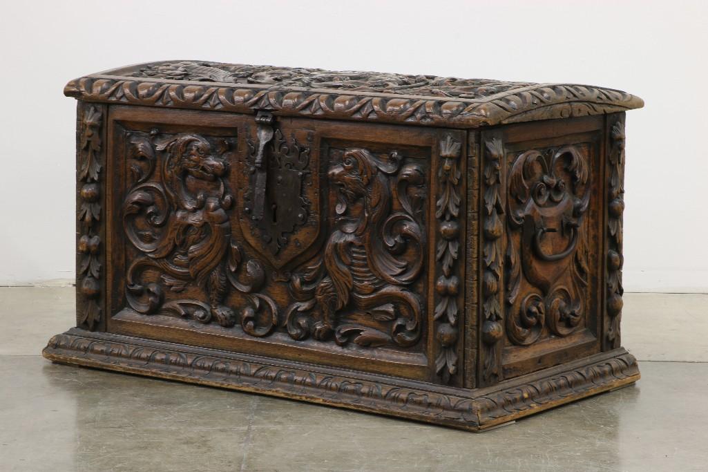 Carved Gothic Spanish Revival Chest w/ Iron Hardware: Depicting lions, angels, and floral motif. Approx. 40.5 in. L x 24.25 T x 23.25 D. 19th Century heavily carved chest with hand wrought iron hardware: handles, lock and iron strap hinges.